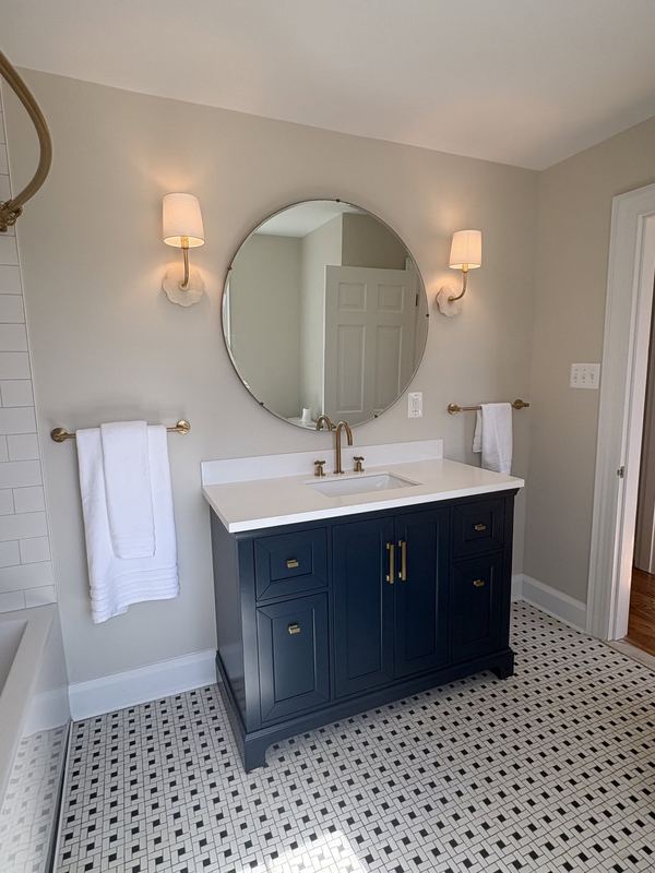 Navy vanity, round mirror, hex tile floor, a bathroom remodel by Sidney Design & Build in Winchester, VA