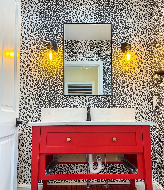 Red vanity and leopard wallpaper, a bathroom remodel by Sidney Design & Build in Winchester, VA