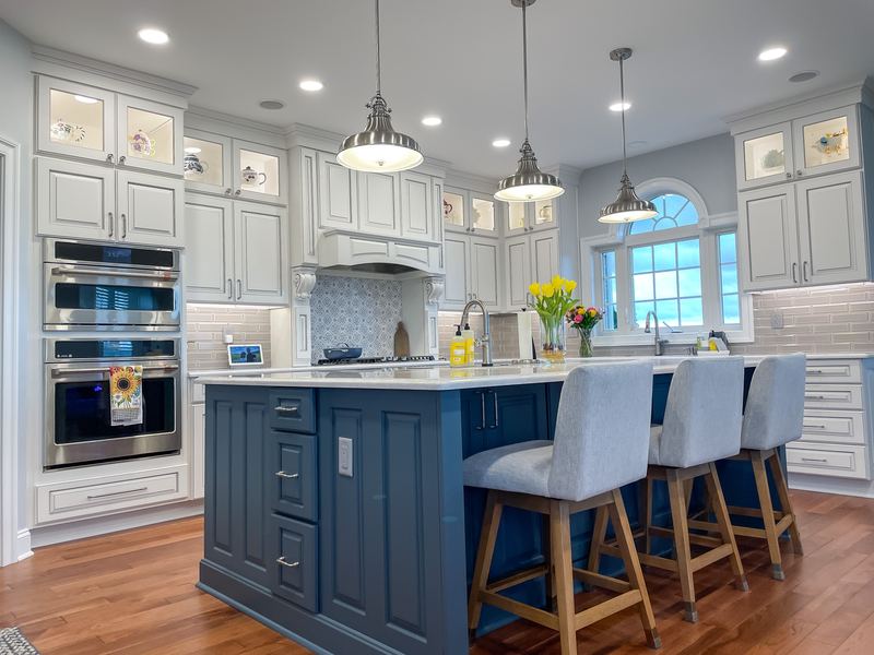 Navy island under a wall of white cabinets, a kitchen remodel by Sidney Design & Build in Winchester, VA