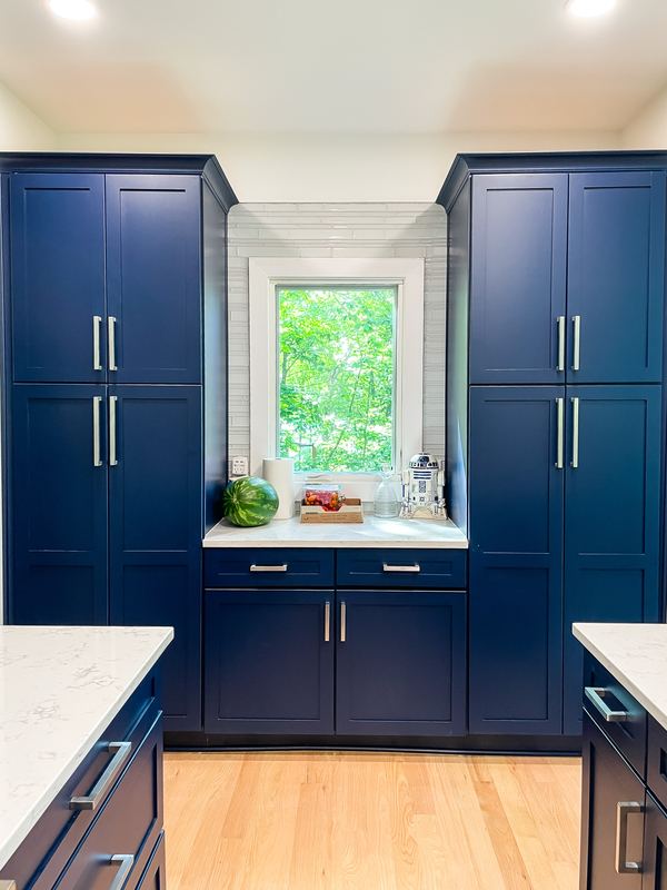 Navy cabinets framing the window, a kitchen remodel by Sidney Design & Build in Winchester, VA