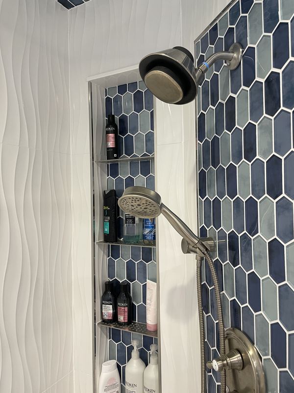 Blue hex tile and a body spray column, a walk in shower by Sidney Design & Build in Winchester, VA