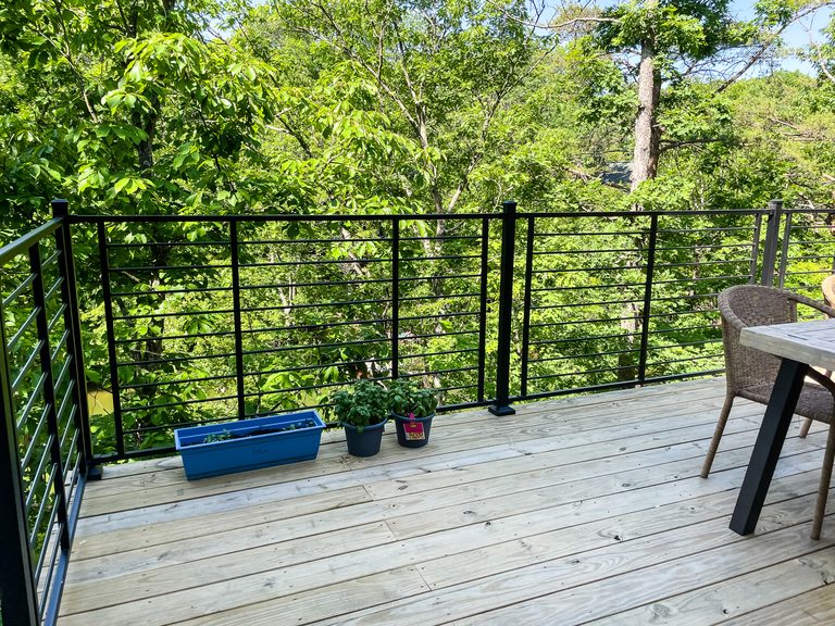 Composite deck with black cable railing in the trees, built by Sidney Design and Build near Winchester, VA