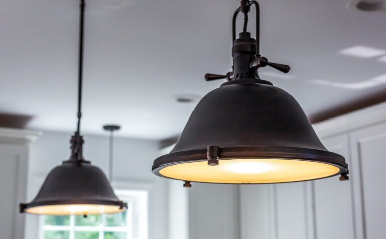 Black dome pendant lights over a remodeled kitchen with white wainscoting in Winchester, VA