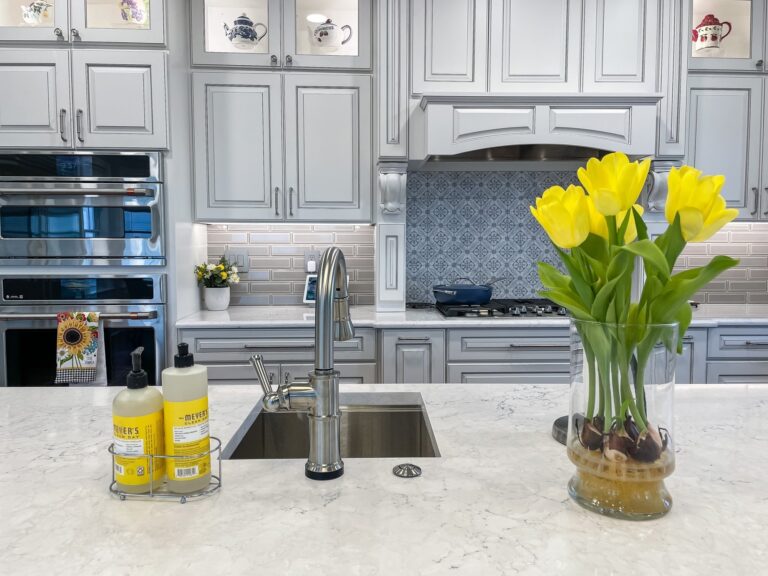 Kitchen remodel with stacked wall ovens, grey cabinets, quartz counters and a blue tile backsplash in Winchester, VA