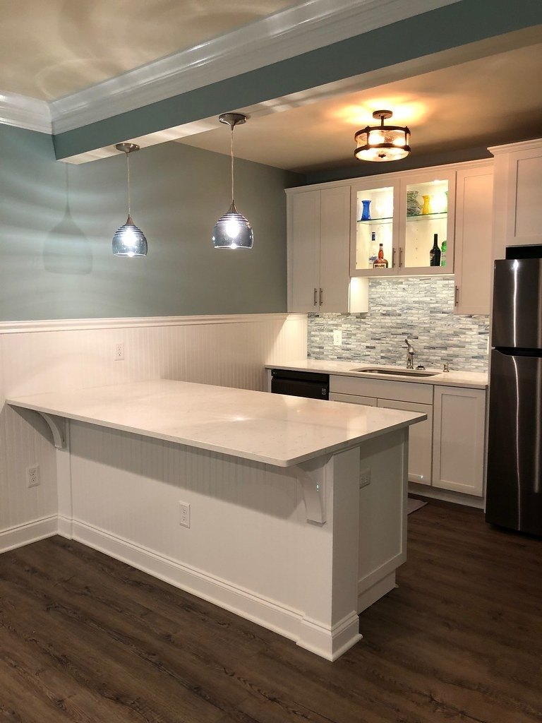 Kitchen remodel with a white quartz peninsula, grey cabinets and glass front uppers in Winchester, VA