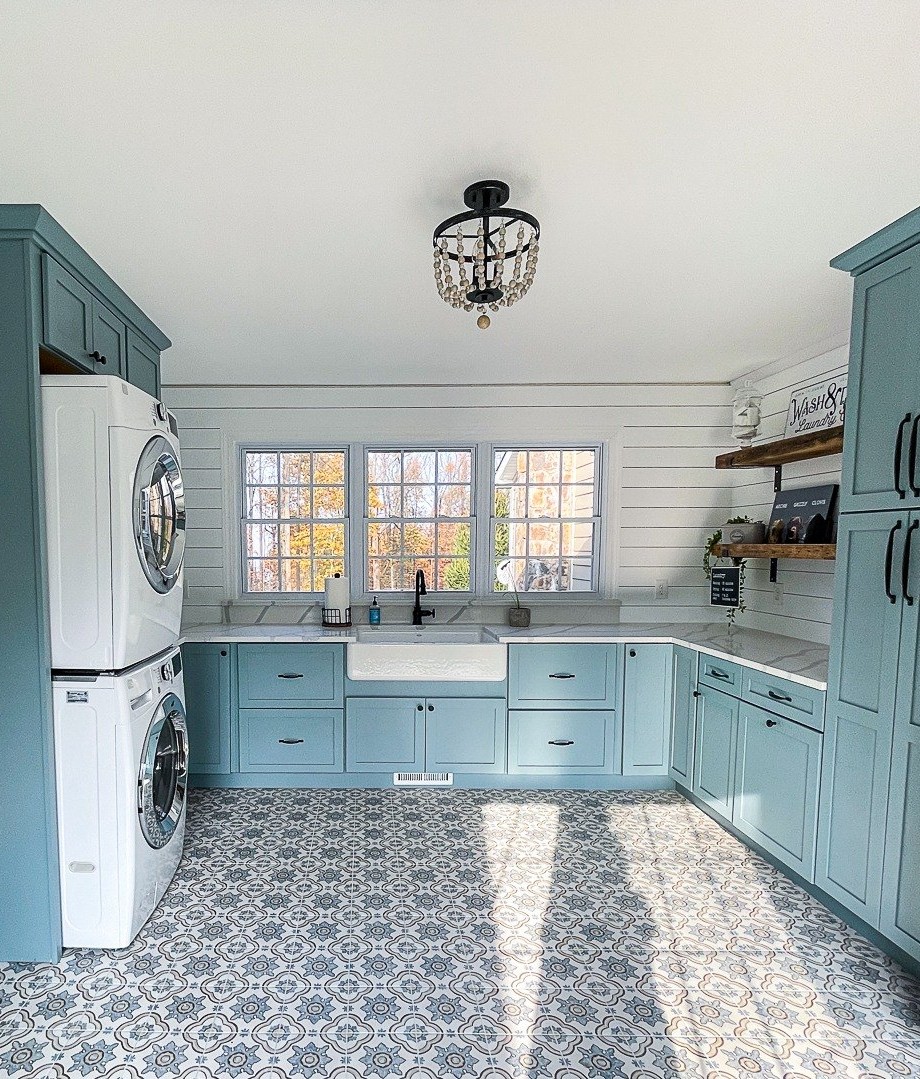 Laundry room remodel with teal cabinets, a stacked washer and dryer, a farmhouse sink and patterned tile floor in Winchester, VA