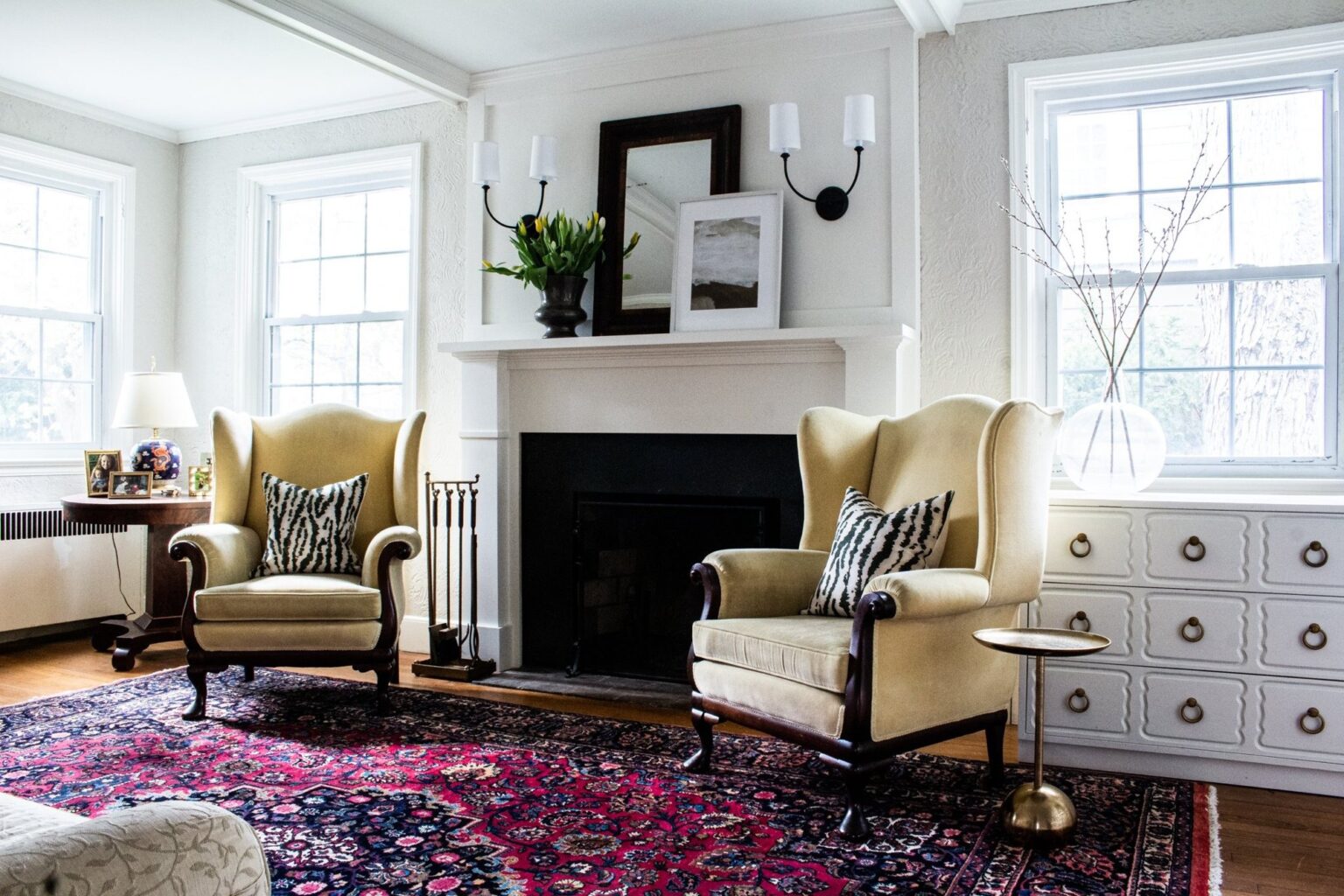 Living room renovation with a painted fireplace, wingback chairs and built in storage in Winchester, VA